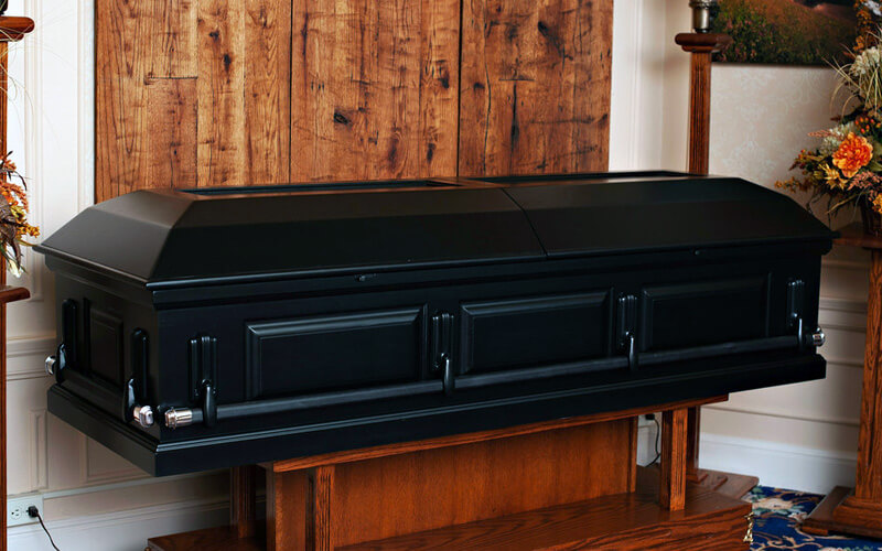 black metal casket on solid wood plinth