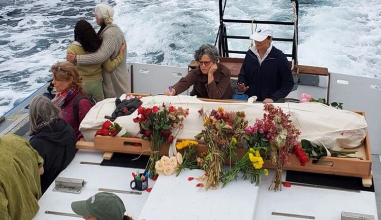 Sea Burial on boat with loved ones, body in shroud